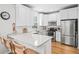 Bright kitchen boasts granite counters, stainless steel appliances, white cabinets, and hardwood floors at 230 W Jamison Cir # 31, Littleton, CO 80120