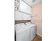 Functional laundry room with a side-by-side washer and dryer, upper cabinets and shelving for ample storage at 230 W Jamison Cir # 31, Littleton, CO 80120