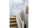 Carpeted staircase with white railing leading up to the second level and window with tree views at 230 W Jamison Cir # 31, Littleton, CO 80120