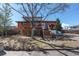 Brick home with backyard deck, privacy fence, and large shade tree at 6361 S Spotswood Cir, Littleton, CO 80120