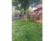 The grassy backyard features mature trees, a deck with pergola, and stone pathways at 6361 S Spotswood Cir, Littleton, CO 80120
