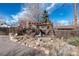 Backyard with stone walkway, landscape boulders, and wooden pergola at 6361 S Spotswood Cir, Littleton, CO 80120