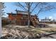 The backyard features a deck with stairs from the second story of this charming brick home at 6361 S Spotswood Cir, Littleton, CO 80120