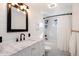 Modern bathroom features marble vanity, black fixtures, and tub with white subway tile at 6361 S Spotswood Cir, Littleton, CO 80120