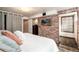 Bedroom featuring brick wall, white bed, and closet access at 6361 S Spotswood Cir, Littleton, CO 80120