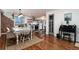 Open dining area with wood floors and an adjacent kitchen with a brick accent wall at 6361 S Spotswood Cir, Littleton, CO 80120