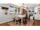 Well-lit dining area features a rustic table, brick accents, and a warm inviting ambiance at 6361 S Spotswood Cir, Littleton, CO 80120