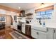 Bright kitchen featuring stainless steel appliances, open shelving, and white subway tile backsplash at 6361 S Spotswood Cir, Littleton, CO 80120