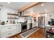 Bright kitchen featuring stainless steel appliances, open shelving, and white subway tile backsplash at 6361 S Spotswood Cir, Littleton, CO 80120