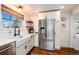 Bright kitchen with stainless steel refrigerator, white cabinets, and subway tile accents at 6361 S Spotswood Cir, Littleton, CO 80120