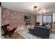 Comfortable living room featuring a brick accent wall and stylish furnishings at 6361 S Spotswood Cir, Littleton, CO 80120