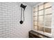 Tiled shower with a glass block window and a sleek showerhead at 6361 S Spotswood Cir, Littleton, CO 80120