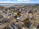 Aerial view showcases neighborhood with community tennis courts, mature trees, and city views at 12592 E Bates Cir, Aurora, CO 80014