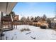 Winter backyard with a wooden deck and covered porch; perfect for entertaining and enjoying the outdoors at 12592 E Bates Cir, Aurora, CO 80014