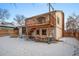 Backyard featuring a wooden deck with stairs, picnic table, and snowy lawn at 12592 E Bates Cir, Aurora, CO 80014