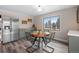 Bright dining area featuring stainless steel appliances, wood-look floors, and a modern table for relaxed dining at 12592 E Bates Cir, Aurora, CO 80014