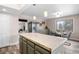 Well-lit kitchen featuring tile countertops, an island, modern appliances, and an adjacent dining area for casual meals at 12592 E Bates Cir, Aurora, CO 80014