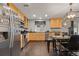 Charming kitchen featuring wooden cabinets and stainless steel appliances with dining area at 5562 Gibraltar St, Denver, CO 80249