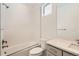 Modern bathroom with sleek subway tile, shower over tub, window, and gray vanity with white countertop at 305 Welded Tuff Trl, Castle Rock, CO 80104