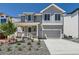 Charming two-story home featuring a stylish gray exterior, landscaped yard, and an attached two-car garage at 305 Welded Tuff Trl, Castle Rock, CO 80104