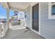 View of the home's covered front porch area with white railings and a gray front door at 305 Welded Tuff Trl, Castle Rock, CO 80104