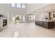 Open-concept living space with tall ceilings, fireplace, light floors, and a modern kitchen island at 305 Welded Tuff Trl, Castle Rock, CO 80104