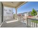 Covered front porch featuring white railings and columns overlooking newly constructed homes at 305 Welded Tuff Trl, Castle Rock, CO 80104