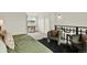 Comfortable bedroom with a plush green bed, seating area, and view from the second story window at 8055 E Colorado Ave # 8, Denver, CO 80231