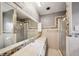 Bright bathroom featuring a walk-in shower, vanity, and large mirror with decorative tile trim at 22081 Paradise Cir, Golden, CO 80401