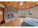Bedroom featuring a stone fireplace, wood ceiling, hardwood floors and three windows at 22081 Paradise Cir, Golden, CO 80401