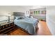 Cozy bedroom featuring hardwood floors, a tufted headboard, and a view to the exterior at 22081 Paradise Cir, Golden, CO 80401