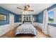 Cozy bedroom with blue walls, hardwood floors, wainscoting, large windows, and stylish ceiling fan at 22081 Paradise Cir, Golden, CO 80401