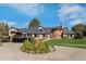 Elegant brick home boasts manicured landscaping, a circular driveway, and a sophisticated architectural design at 22081 Paradise Cir, Golden, CO 80401