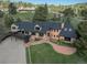 Charming two-story brick home with a deck, lush lawn and mature trees surrounding the property at 22081 Paradise Cir, Golden, CO 80401