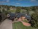 Charming two-story brick home with a deck, lush lawn and mature trees surrounding the property at 22081 Paradise Cir, Golden, CO 80401