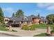 Attractive brick home showcases manicured landscaping, a circular driveway, and a distinctive turret design at 22081 Paradise Cir, Golden, CO 80401