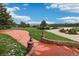 Front yard featuring manicured lawn, brick accents, and a paved driveway with views at 22081 Paradise Cir, Golden, CO 80401