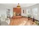 Bright living room featuring a brick fireplace, hardwood floors, and natural light from the windows at 22081 Paradise Cir, Golden, CO 80401