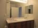 Bright bathroom featuring a double sink vanity, large mirror and a shower with glass doors at 2239 Calais Dr # E, Longmont, CO 80504