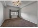 This bedroom features a ceiling fan, a large window and neutral colored carpet at 2239 Calais Dr # E, Longmont, CO 80504