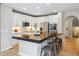 Bright kitchen with white cabinets, stainless steel appliances, modern bar stools, and a breakfast bar area at 2792 Greatwood Way, Highlands Ranch, CO 80126