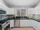 Well-lit kitchen featuring tile backsplash, white cabinets, stainless steel appliances at 22 S Indiana Pl, Golden, CO 80401