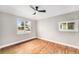 Cozy bedroom featuring hardwood floors, neutral walls, a ceiling fan, and a bright window at 5100 Clay St, Denver, CO 80221