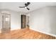 Spacious bedroom featuring hardwood floors, ceiling fan, and access to en-suite bathroom at 5100 Clay St, Denver, CO 80221