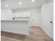 Basement bar area featuring light wood-look floors, white cabinets, white walls, and a white door at 8145 Cokedale Cir, Littleton, CO 80125