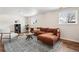 Modern living room with hardwood floors, windows, and an inviting orange sectional sofa at 5153 Tucson Way, Denver, CO 80239