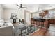 Open-concept living room flows into kitchen with bar seating, featuring hardwood floors and modern furnishings at 5153 Tucson Way, Denver, CO 80239