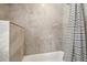 Stylish tiled shower area featuring a modern shower curtain, offering a spa-like experience and elegant design at 5153 Tucson Way, Denver, CO 80239