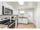 Well-lit kitchen with stainless steel appliances, granite countertops, and white cabinetry at 8260 Washington St # 78, Denver, CO 80229