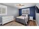 Cozy bedroom with a blue accent wall and natural light at 9630 N Surrey Dr, Castle Rock, CO 80108
